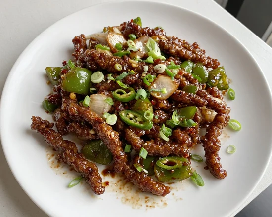Crispy chilli beef strips with green pepper, onion, green chillies and spring onion